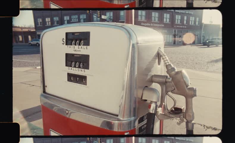A vintage red and chrome gas pump likely from an older era stands prominently with its classic design and analog meters visible the setting suggests an outdoor scene possibly an oldfashioned service station or a roadside stop