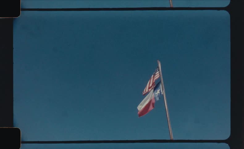 Two flags flying in the bright blue sky