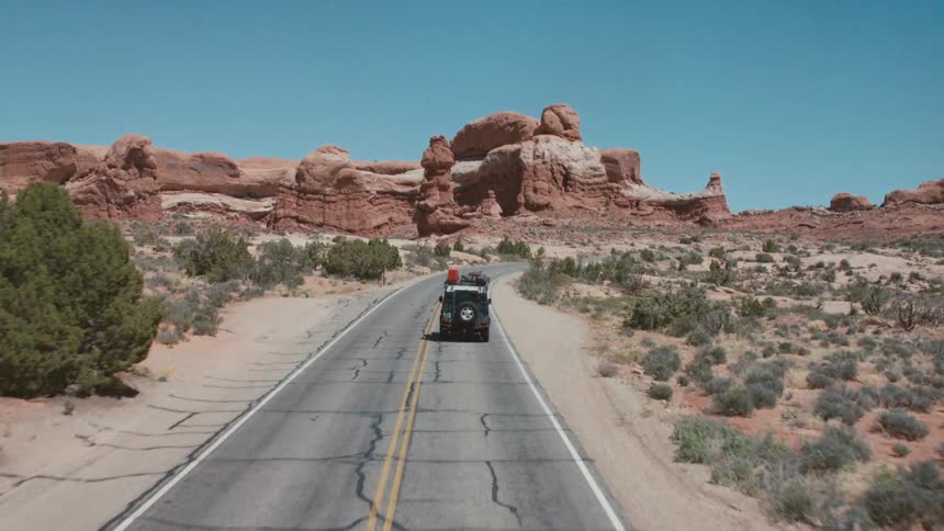 A jeep driving down a two lane road