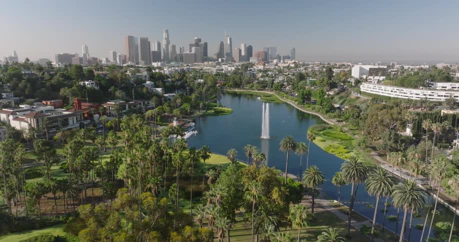 Echo Park Lake and fountain is seen from above with skyscrapers of downtown Los Angeles in the background