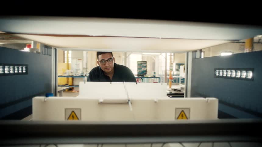 Man looks over the contents of a workstation in a factory