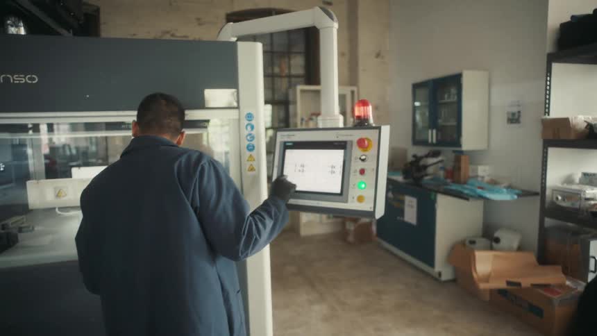 A factory worker is using machines