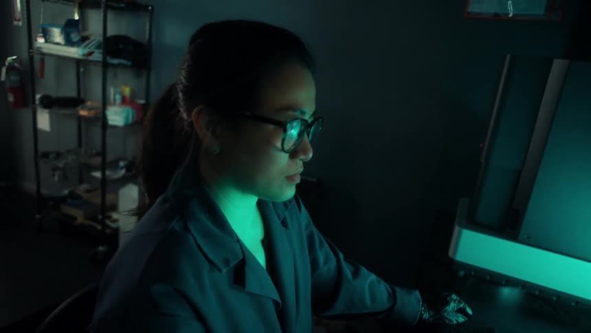 Close up of a woman working on a desktop computer in an office in a lab factory