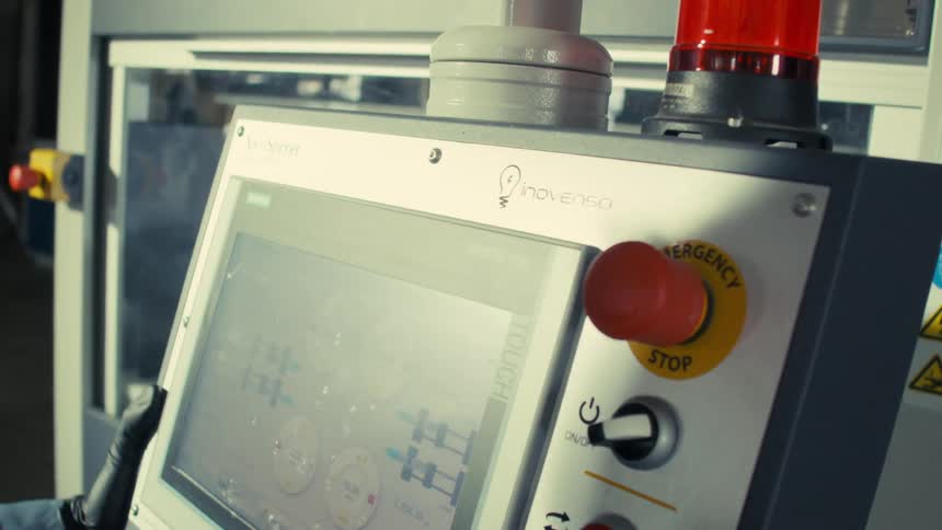Worker at a factory manipulates an electrospinning machine