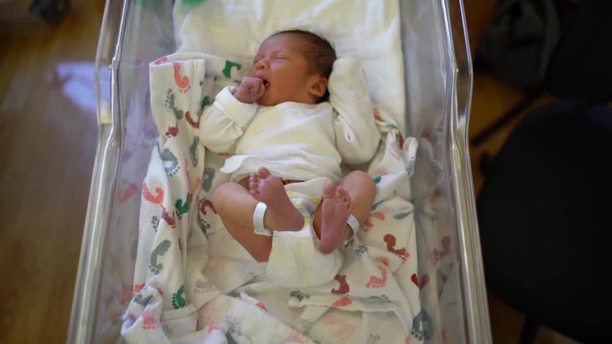A baby is moving around in a crib
