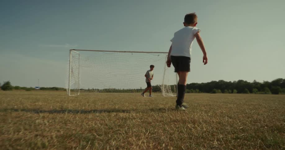 Goalkeeper player in a soccer match both boys on an outdoor field