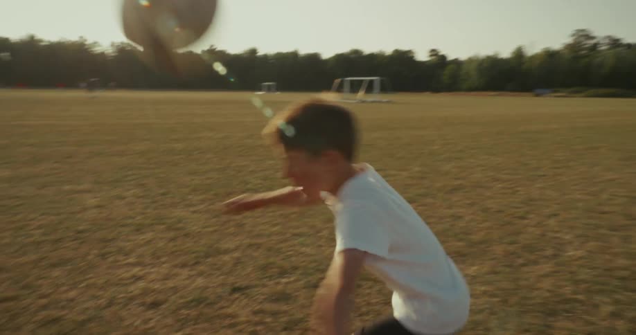 Boy heading a soccer ball on a field