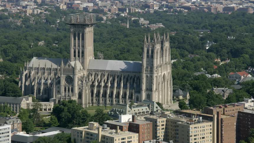 A cathedral is surrounded by buildings and trees