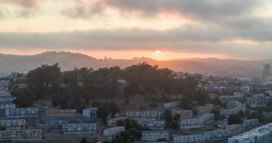 Aerial view of houses in mountains with sunrise on the horizon