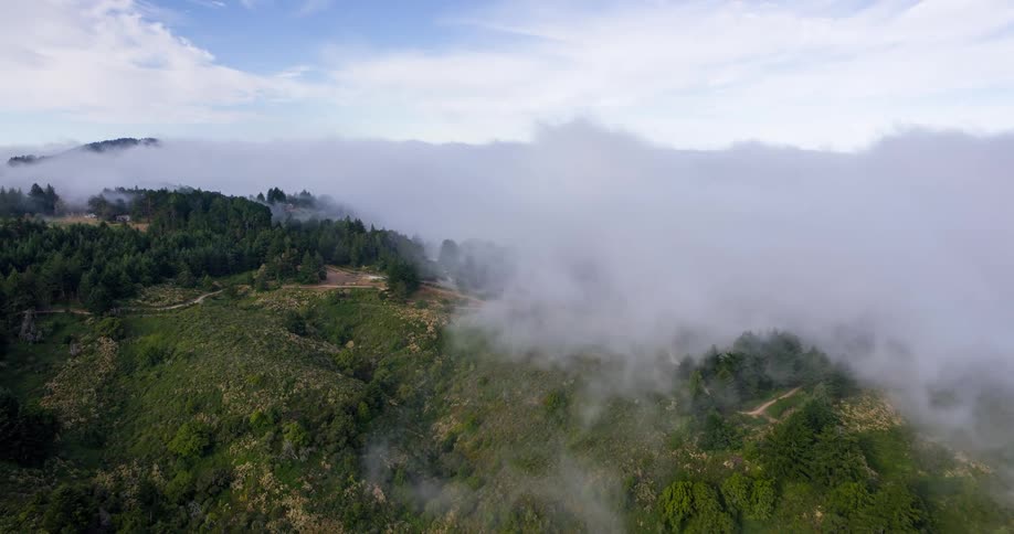 Flying over land obscured by mist