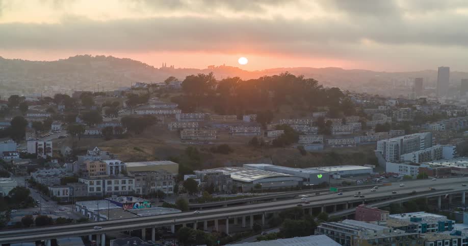 The sun is setting as traffic move son the freeway through town
