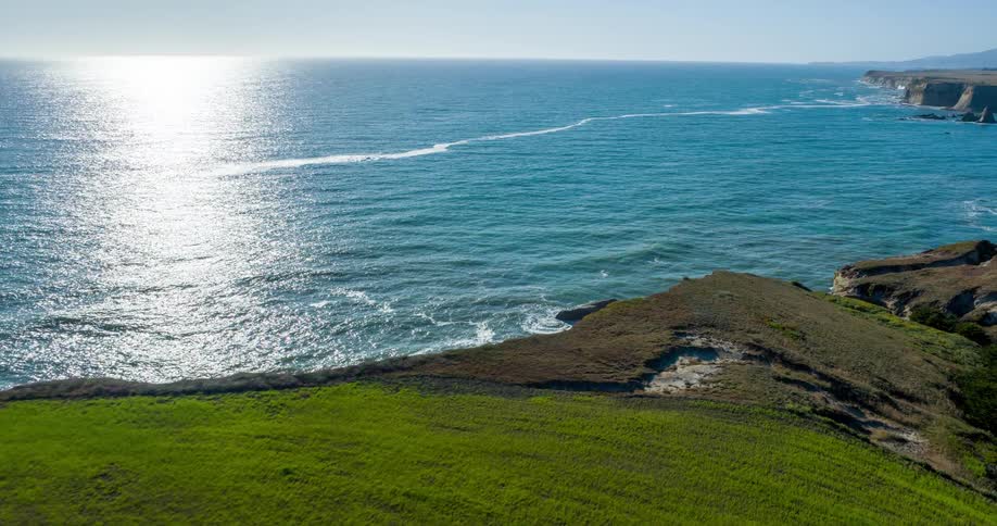 Aerial view of the sea coast with sun reflection