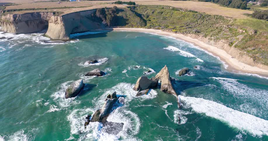 Rocks in an ocean with the coast in the background