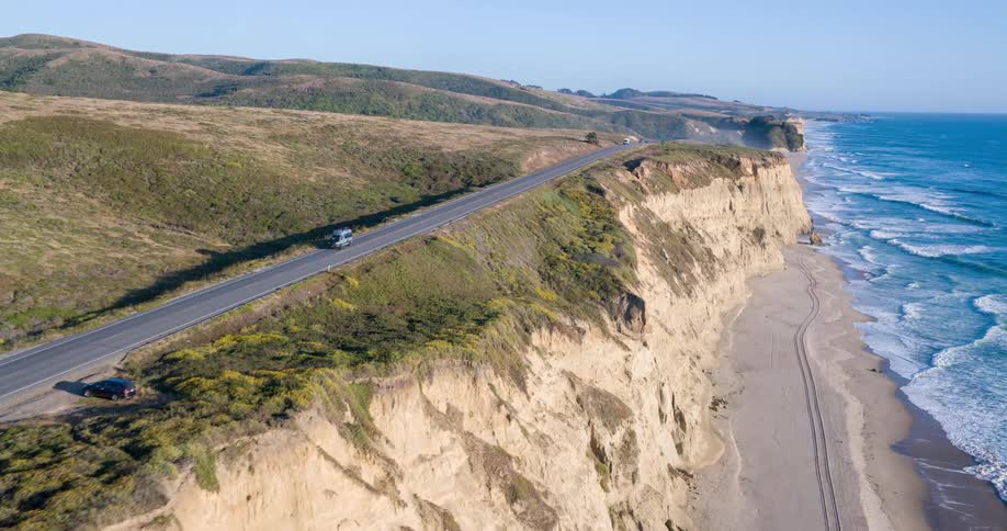 Cars travel on the small road on the cliff