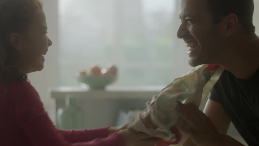 A man and girl play in the kitchen