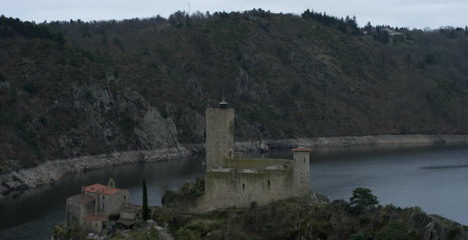 A stone building sits by the shore line