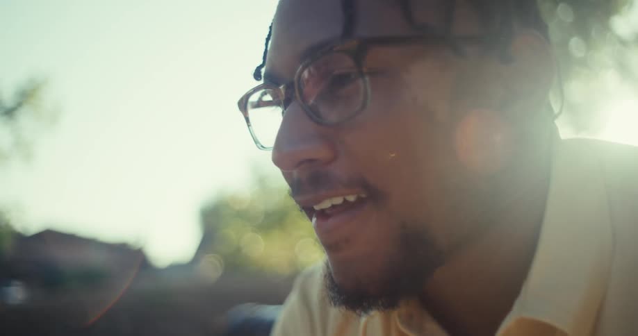 Man sitting on a bench outdoors with a happy expression