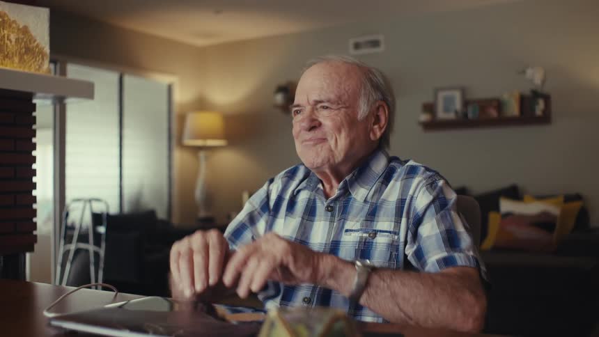 Elderly man closing laptop and celebrating happily
