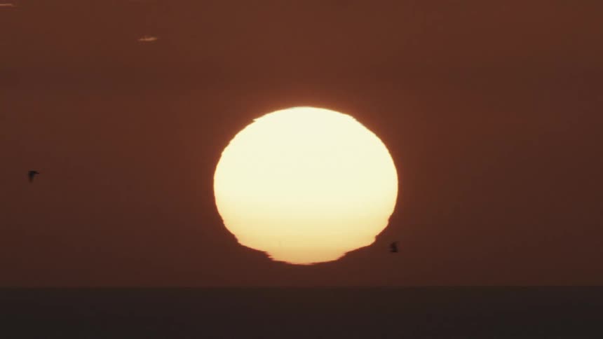 A sun sets over a body of water