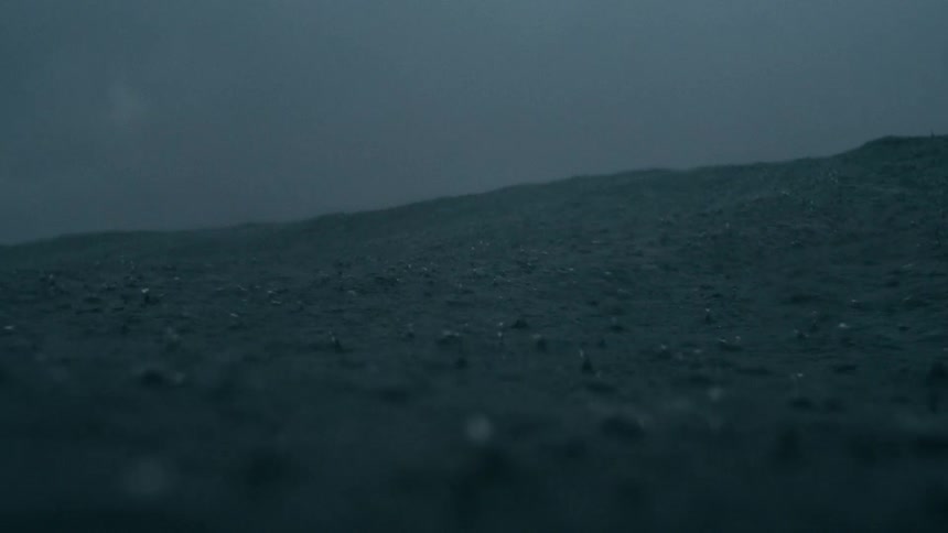 Heavy rain falling into a rippling ocean