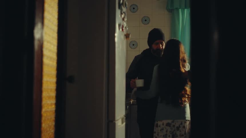 Daughter walks into the room and hugs her dad
