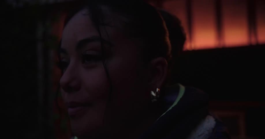 Woman in a lowlit room with a happy expression