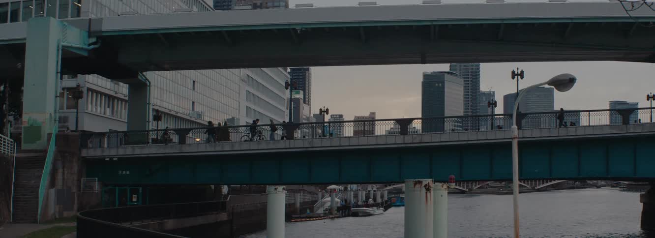 Rush hour in Osaka japan as people walk over an urban bridge at sunset