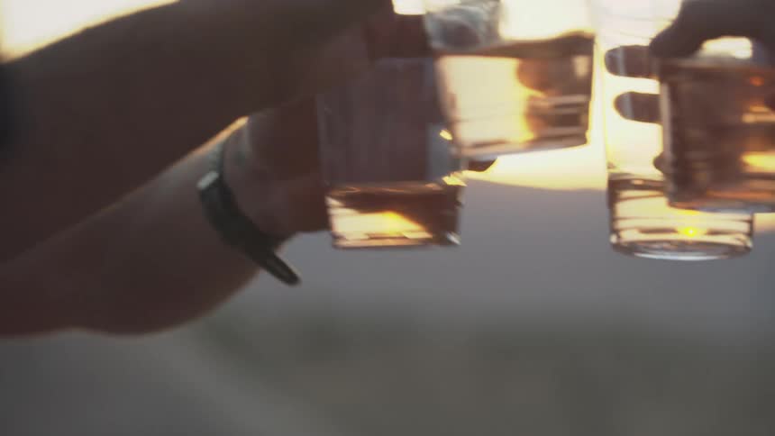 Two people toast drinks outside