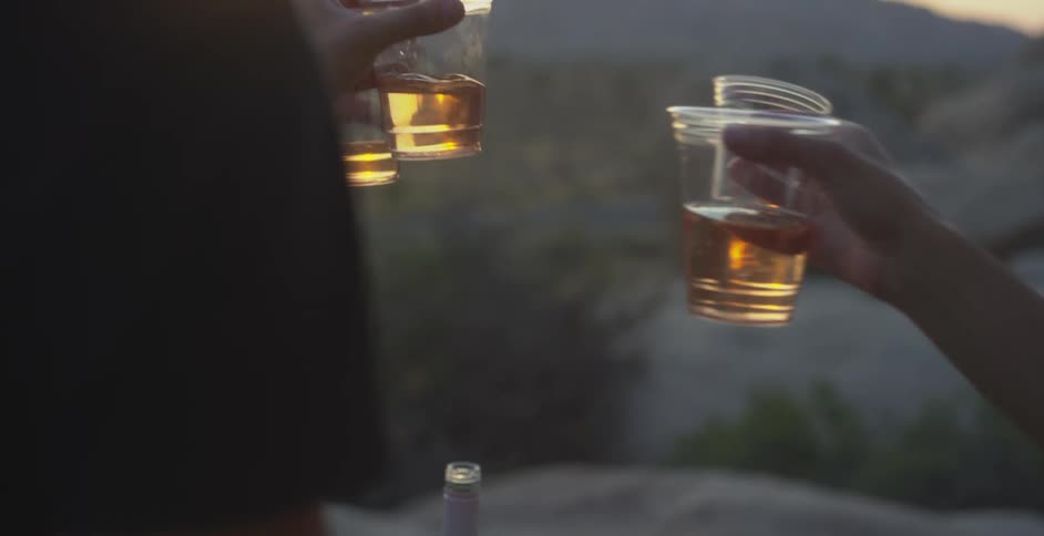 People toasting with disposable cups of drink outdoors