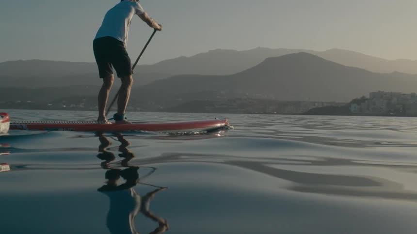 Two people stand up paddleboarding in the ocean