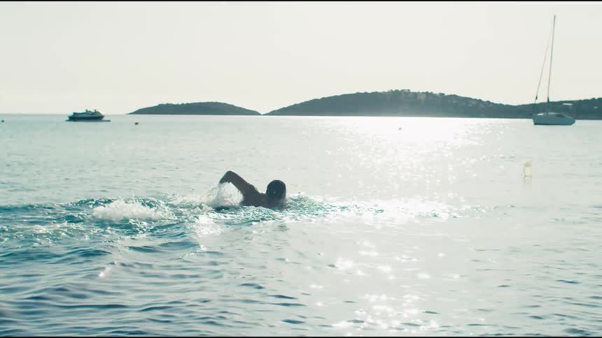 A man is swimming away from the shore