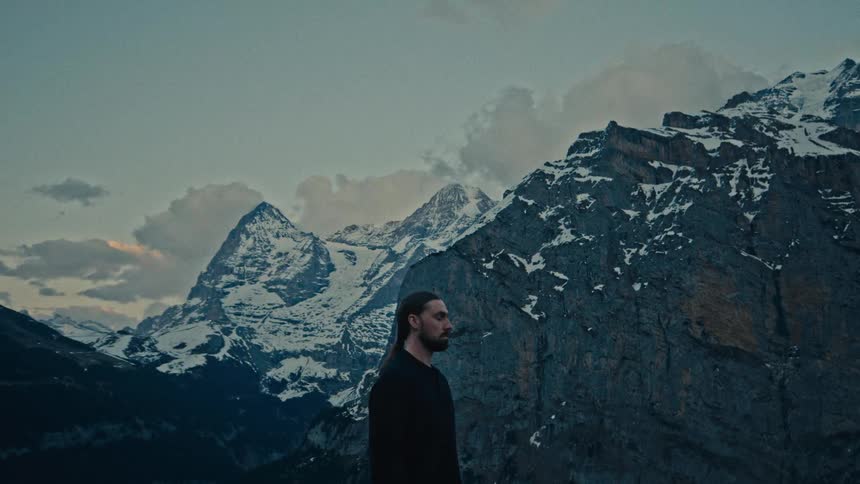 A man meditates by some mountains