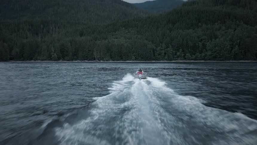 The boat is heading straight towards the shore with mountains