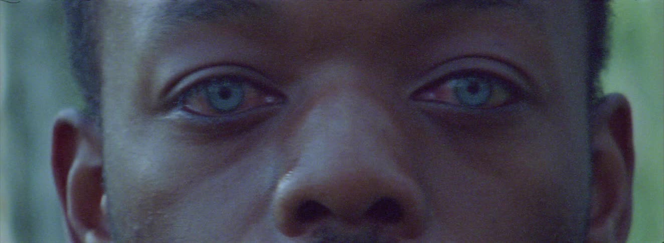 The man with blue eyes is standing outside
