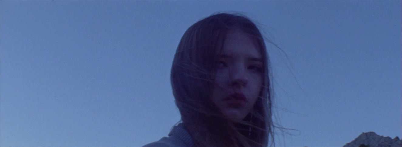 Young woman in the mountains at dusk