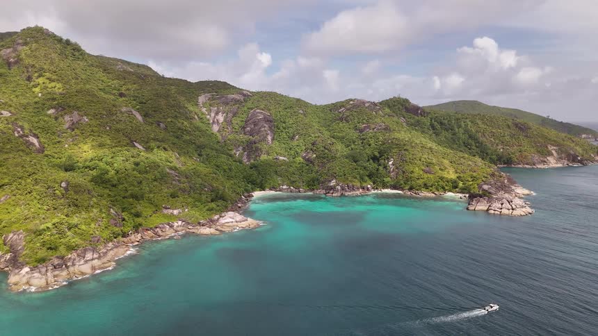 Imposing forested mountains bordering a turquoise sea