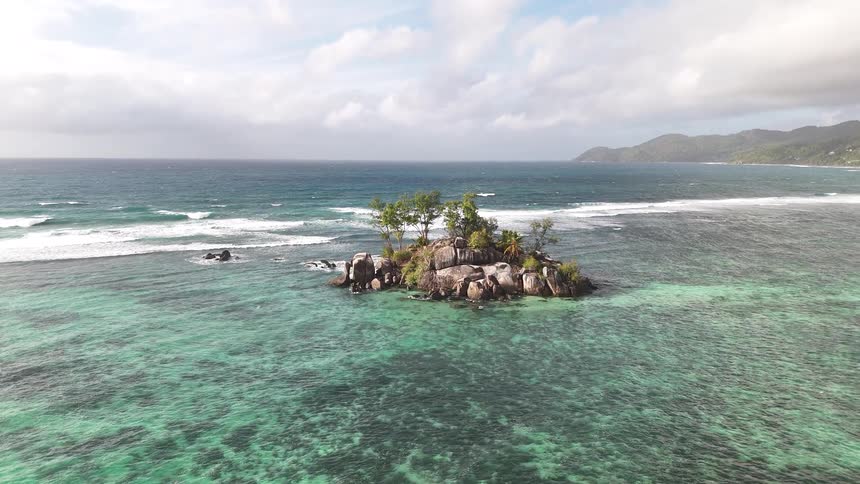 Aerial panorama of a small isolated island in a turquoise blue sea