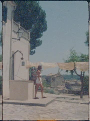 Woman hanging clothes on a clothesline outdoors