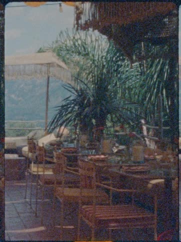 Outdoor table set for a meal stands on a terrace on a foggy summer day