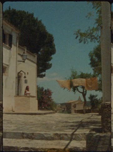 A female steps outside to hang laundry on a line outside