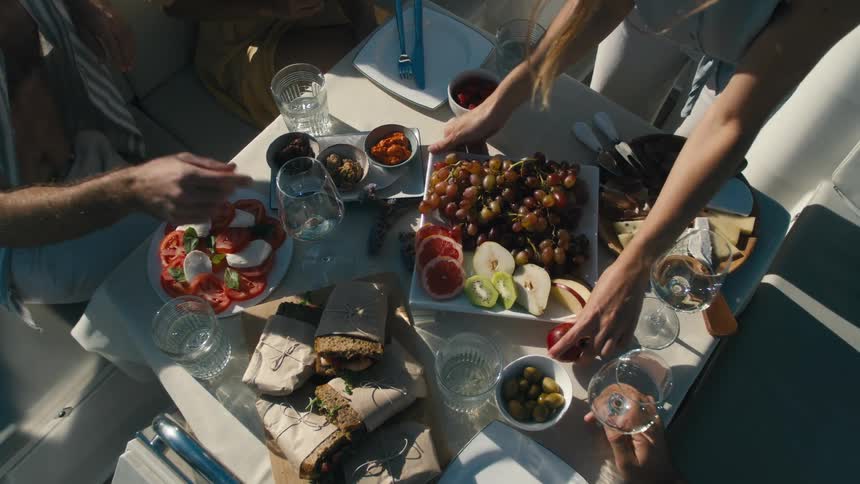 People around a small table with fruit bread and wine
