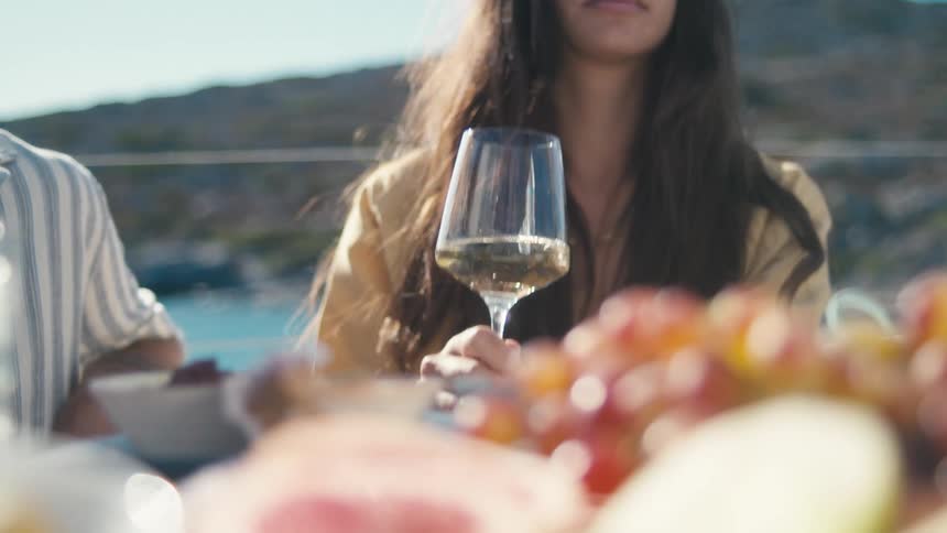 A woman is drinking wine outside