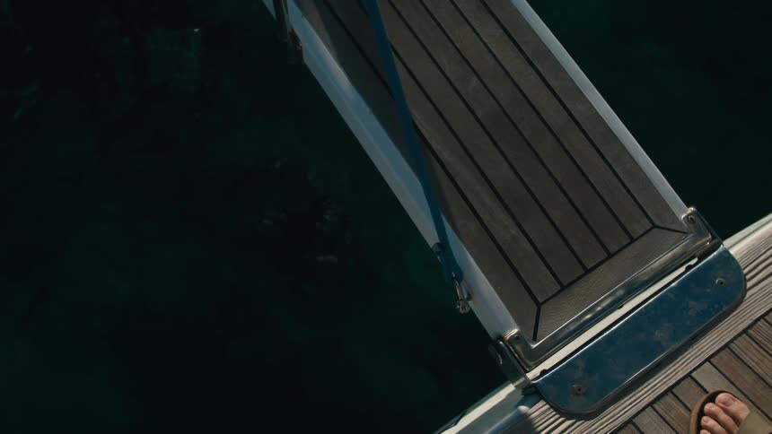 Person walking along a narrow support of a boat