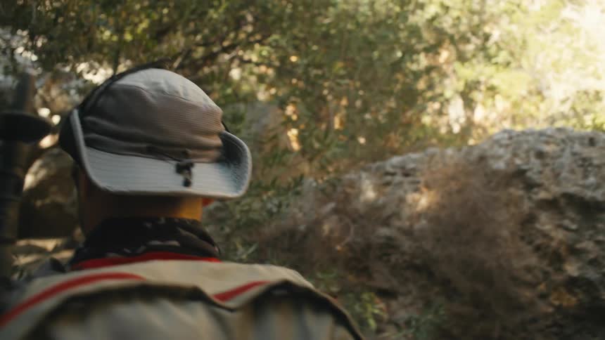 A man is hiking and climbing over rocks