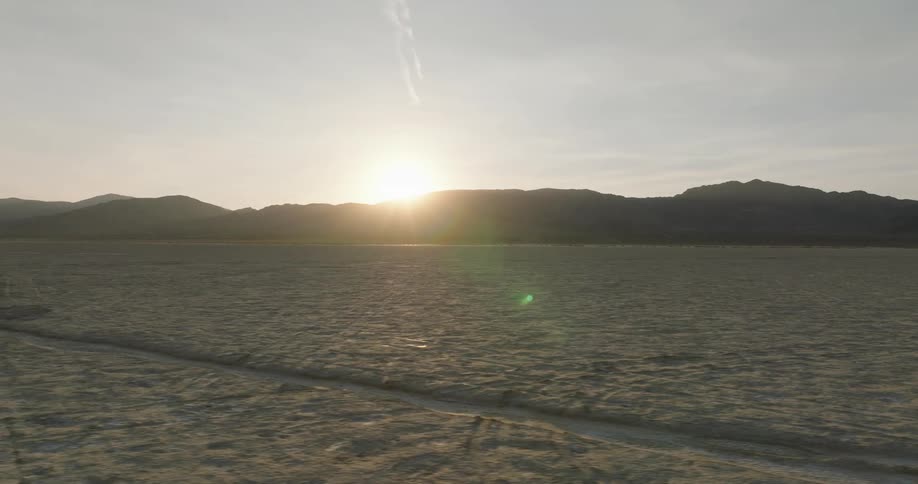 The sun is rising on the desert