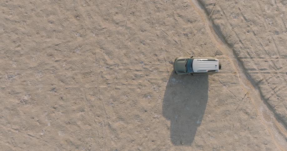 Aerial view of a car traveling on a dirt road