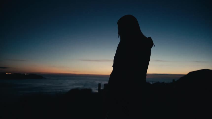 A woman is watching the sunset