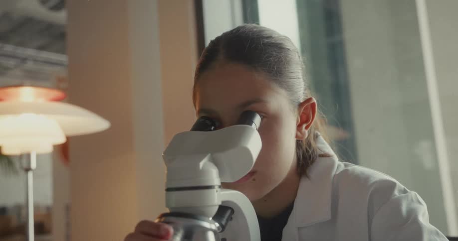 A scientist is looking through a microscope