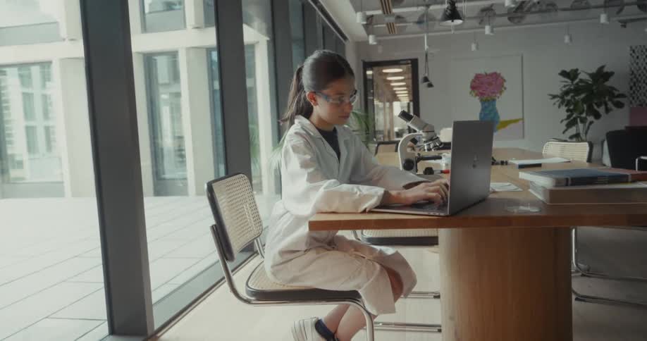 A woman types on a laptop
