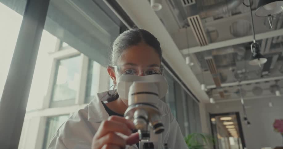 Woman interacting with microscope